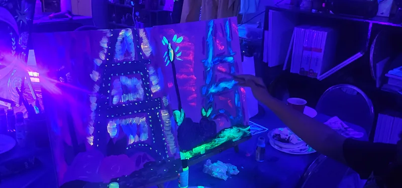 Glow paintings displayed under ultraviolet light