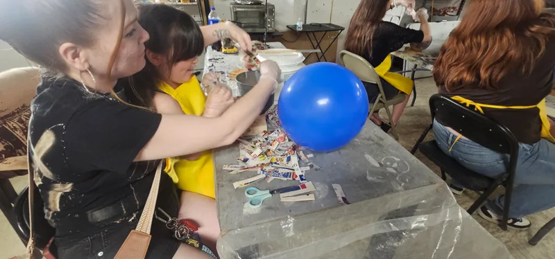 A member of staff helping a young maker